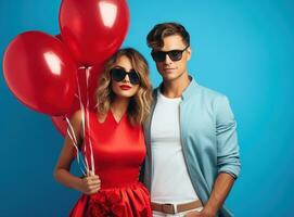 beautiful couple in arm on blue background with balloons in their hands photo