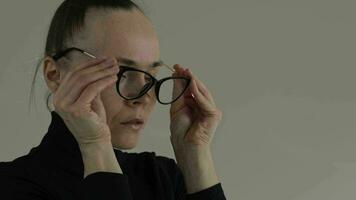 en kvinna i en svart turtleneck Tröja bär glasögon på henne ansikte video