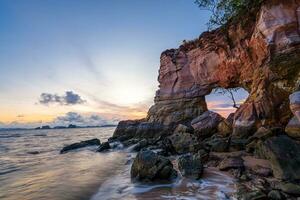 Buffalo Nose Cape, Ao Tha Len, Krabi Province, Thailand, rocky cliff with a hole through which you can pass through. It looks like an elephant's trunk. Sunset time is very beautiful. photo