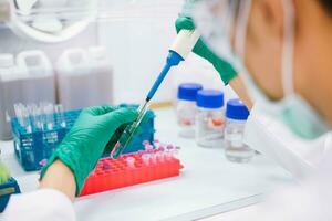 Close up scientist using pipette transfer sample to Micro Centrifuge Tube for PCR test in Biosafety cabinet. photo