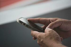 He held a smartphone in his hand and was typing a chat message with a friend. photo