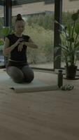 a woman is doing yoga in front of a plant video