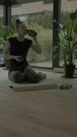 a woman is doing yoga in front of a plant video