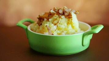 Cooked mashed potatoes with fried chopped bacon and onions in a bowl. video