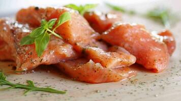 Fresh big pieces of salted red fish with spices and herbs on a wooden board. video