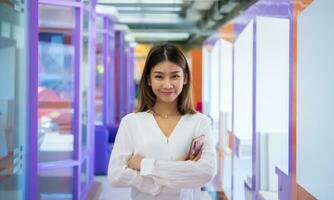 Beautiful asian business woman stands with her arms crossed exuding confidence and professionalism, Digital marketing. photo