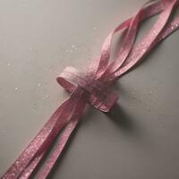 Pink ribbon on a gray background with confetti. Top view. AI Generative photo