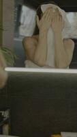 uma mulher dentro uma toalha é olhando às ela mesma dentro a espelho video
