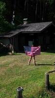 a woman holding an american flag in front of a cabin video