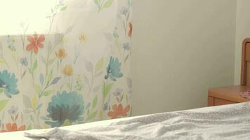 a child sleeping on a bed with a white sheet and a floral curtain video