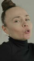 Porträt von ein glücklich Frau mit ein Brötchen Frisur und ein schwarz Rollkragen video