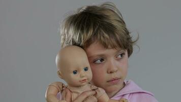 a young child holding a doll in front of him video