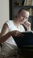 a woman is sitting at a table with a book video