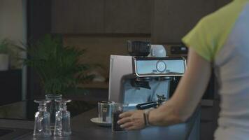 a woman is making a coffee using a coffee machine video