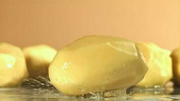 Peeled potatoes fall on a wet table. Filmed on a highspeed camera at 1000 fps. High quality FullHD footage video