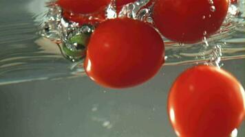 tomaten vallen onder water in een pan. gefilmd Aan een hoge snelheid camera Bij 1000 fps. hoog kwaliteit full HD beeldmateriaal video