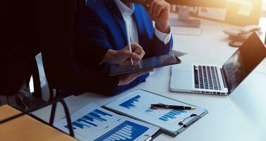 empresario empresario asiático y mujer de negocios discutiendo un nuevo proyecto de negocios en tableta en una reunión moderna en una oficina moderna, concepto casual de negocios asiáticos. foto