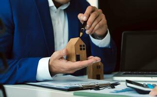 Female woman hands holding home model, small miniature white toy house. Mortgage property insurance dream moving home and real estate concept photo