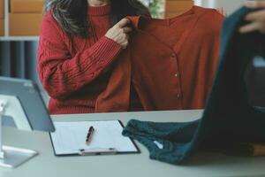 empresaria de pequeñas empresas de nueva creación de una mujer asiática independiente que usa una computadora portátil con una caja de éxito alegre mujer asiática su mano levanta la caja de embalaje de marketing en línea y el concepto de idea de sme de entrega foto