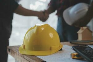 Close up of civil male engineer asian working on blueprint architectural project at construction site at desk in office. photo