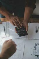 Close up of civil male engineer asian working on blueprint architectural project at construction site at desk in office. photo