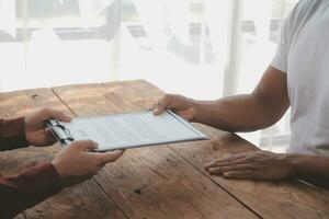 Close up view of job interview in office, focus on resume writing tips, employer reviewing good cv of prepared skilled applicant, recruiter considering application, hr manager making hiring decision photo