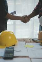 Close up of civil male engineer asian working on blueprint architectural project at construction site at desk in office. photo