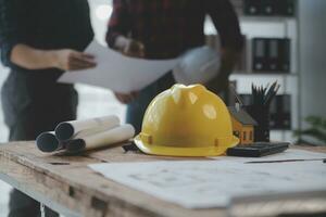 Close up of civil male engineer asian working on blueprint architectural project at construction site at desk in office. photo