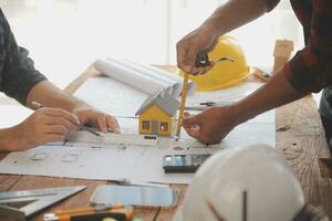 Close up of civil male engineer asian working on blueprint architectural project at construction site at desk in office. photo