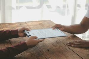 Close up view of job interview in office, focus on resume writing tips, employer reviewing good cv of prepared skilled applicant, recruiter considering application, hr manager making hiring decision photo