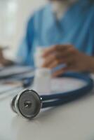 Stethoscope and background doctor using laptop at desk in clinic working on computer at room office. photo