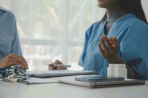 Asian doctor woman visited patient woman to diagnosis and check up health at home or private hospital. Female patient explain health problem and symptoms to doctor .Health care premium service at home photo