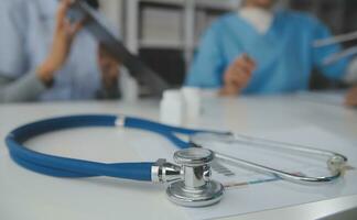 Stethoscope and background doctor using laptop at desk in clinic working on computer at room office. photo