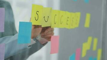 Young asian business woman working on project plan using sticky papers notes on glass wall, people meeting to share idea, Business design planning concepts. video