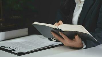 zaken en advocaten bespreken contractpapieren met koperen schaal op bureau in kantoor. wet, juridische diensten, advies, rechtvaardigheid en wet concept foto met film grain effect video