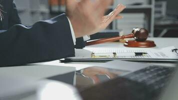 Business and lawyers discussing contract papers with brass scale on desk in office. Law, legal services, advice, justice and law concept picture with film grain effect video