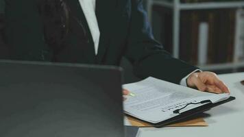 Business and lawyers discussing contract papers with brass scale on desk in office. Law, legal services, advice, justice and law concept picture with film grain effect video