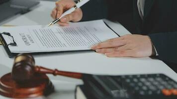 Business and lawyers discussing contract papers with brass scale on desk in office. Law, legal services, advice, justice and law concept picture with film grain effect video