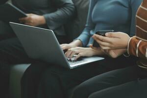 Tres hermosa asiático muchachas utilizando teléfono inteligente y computadora portátil, chateando en sofá juntos a café con Copiar espacio, moderno estilo de vida con artilugio tecnología o trabajando mujer en casual negocio concepto foto