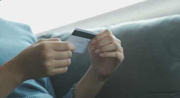 A credit card in the hands of a young businesswoman pays for a business on a mobile phone and on a desk with a laptop. photo