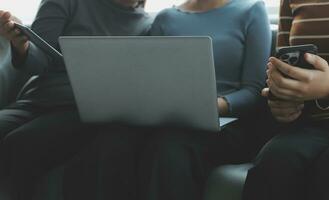 Tres hermosa asiático muchachas utilizando teléfono inteligente y computadora portátil, chateando en sofá juntos a café con Copiar espacio, moderno estilo de vida con artilugio tecnología o trabajando mujer en casual negocio concepto foto