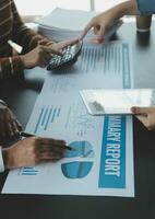 Financial analysts analyze business financial reports on a digital tablet planning investment project during a discussion at a meeting of corporate showing the results of their successful teamwork. photo