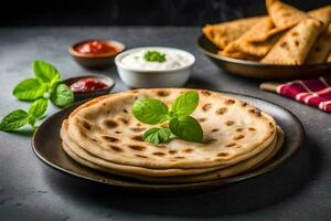 indian flatbreads on a black plate with sauce and mint leaves. AI-Generated photo