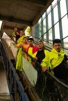 a group of Asian men in green shirts lined up on the stairs in an old building photo