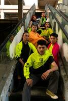 a group of Asian men are relaxing on the stairs with their friends at a university photo