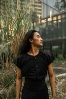 an Asian man with long hair and wearing black clothes standing around an abandoned building photo