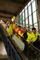 a group of Asian men in green shirts lined up on the stairs in an old building photo