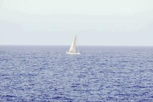 a sailboat is out in the open ocean photo