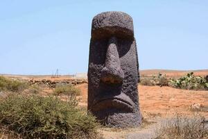 a large stone statue in the middle of a desert photo