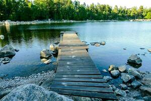 a wooden dock extends into the water near a lake photo